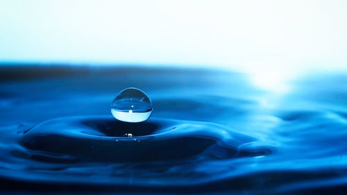 Close-up of water drop on blue surface