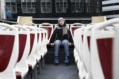 Tween boy sits alone on top of double decker bus in london