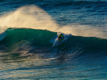 Person surfing on waves at sea