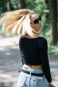 Midsection of woman wearing sunglasses standing outdoors