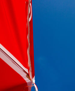 Low angle view of flag against blue sky