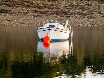 Red boat moored in lake