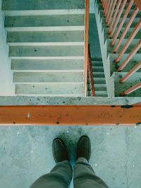 Low section of man standing on staircase