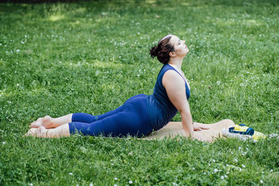 Happy confident smiling plus size curvy woman doing yoga stretching pilates workout, exercising