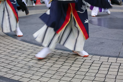 Low section of men walking on street