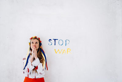 Portrait of woman standing against wall