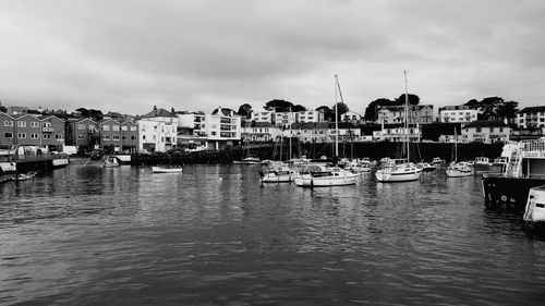 Boats in harbor by buildings in city