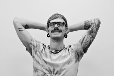 Portrait of young man standing against white background