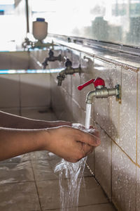 Midsection of person holding water in bathroom