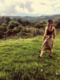 Woman standing on field against sky