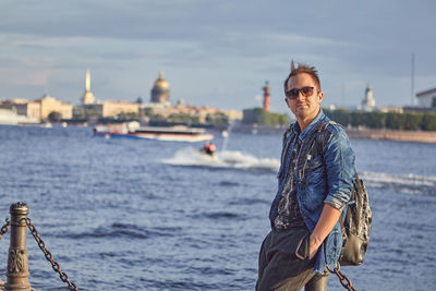 Portrait of man standing against canal