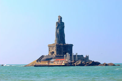 Statue in sea against clear sky