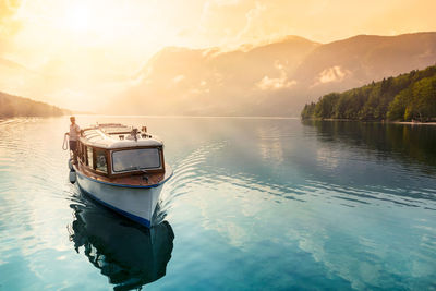 Boat on sea against sky during sunset