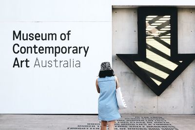 Rear view of woman standing against wall