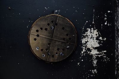 Close-up of rusty wheel against black background