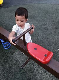 High angle view of cute baby boy standing by play equipment