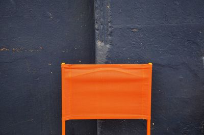 Orange chair against black wall