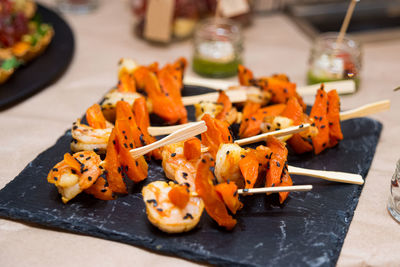 Shrimp sweet potato kebab in black sesame seeds on slate board