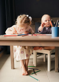 Cute girl sitting on table at home