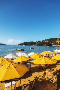 Scenic view of beach against clear blue sky