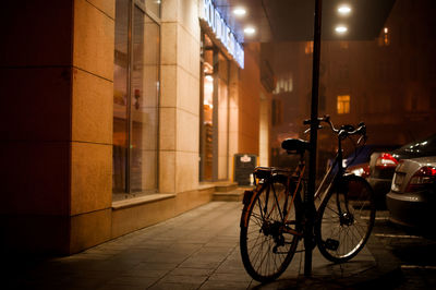 Bicycle parked on street at night