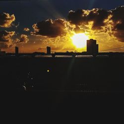 Silhouette of city against sky during sunset