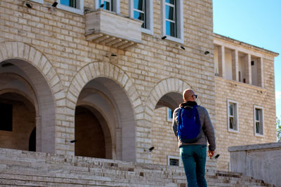 Full length rear view of man walking in building