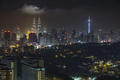 Illuminated cityscape against sky at night