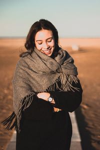 Portrait of a smiling young woman standing on beach