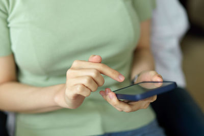 Midsection of man using mobile phone