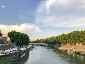 Scenic view of river against sky in city