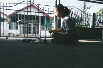 Happy girl playing with cat in front yard