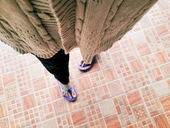 Low section of people walking on tiled floor