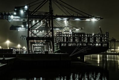 Illuminated bridge over river at night