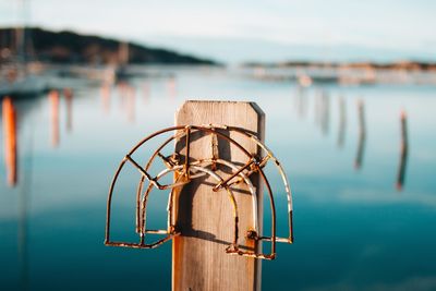 Close-up of wooden post in sea against sky