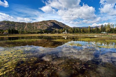 Scenic view of lake by mountain against sky