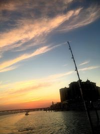 Scenic view of sea by buildings against sky during sunset