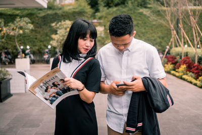 Young man using mobile phone while standing outdoors