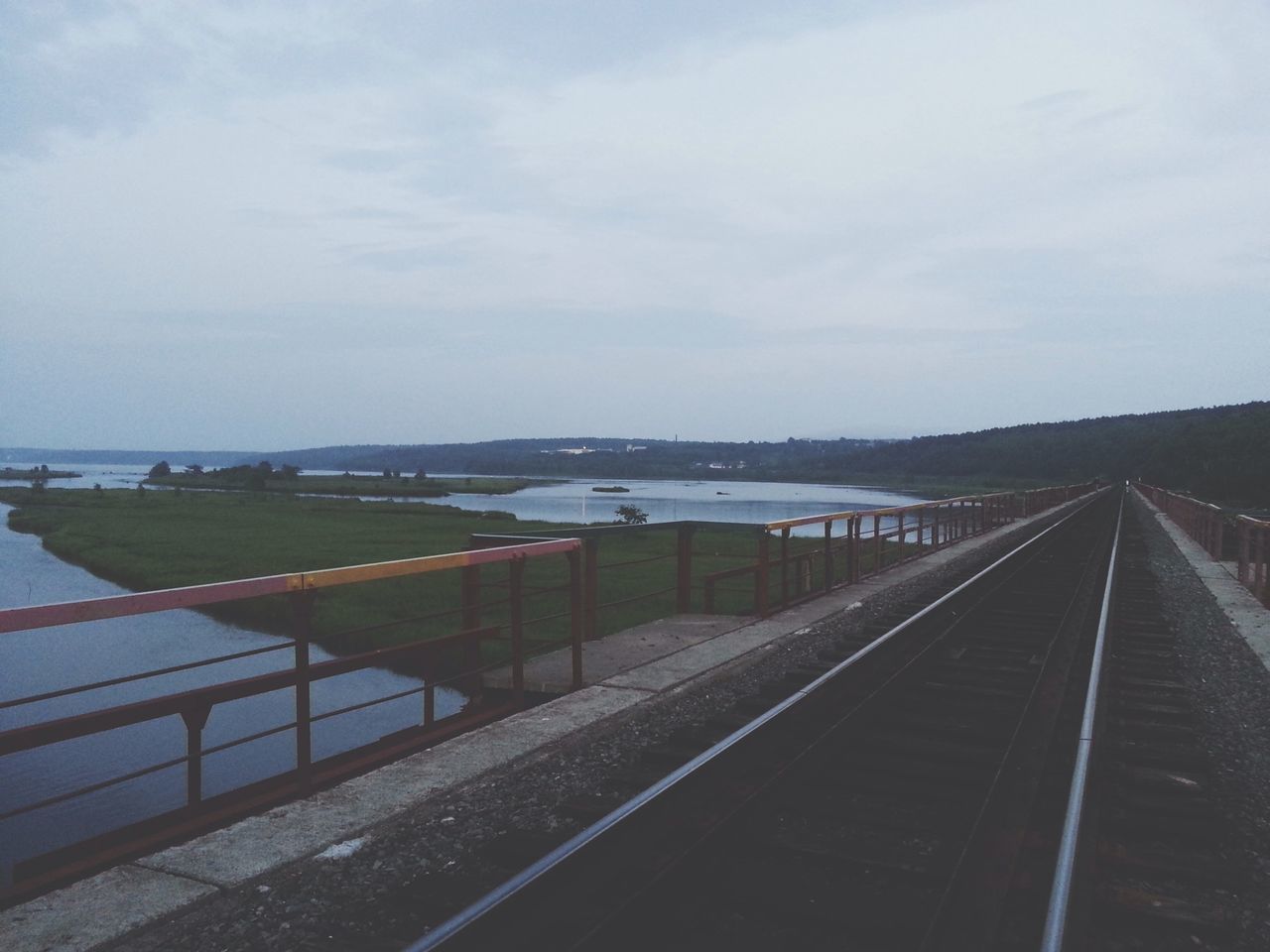 sky, transportation, the way forward, cloud - sky, railroad track, diminishing perspective, railing, vanishing point, road, cloudy, built structure, cloud, day, rail transportation, outdoors, no people, high angle view, road marking, nature, empty