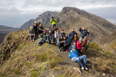 Group of people on mountain against sky