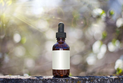 Close-up of glass bottle on retaining wall