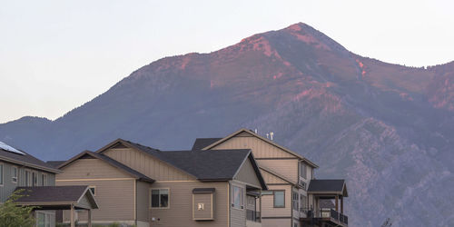 Houses by mountains against sky