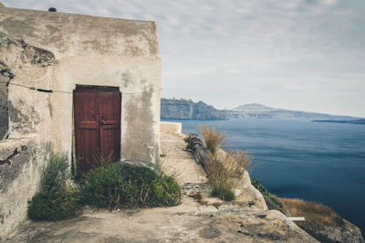 Built structure by sea against sky