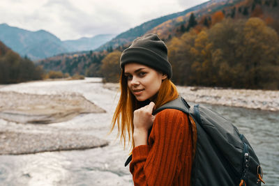Portrait of beautiful young woman standing against mountains during winter