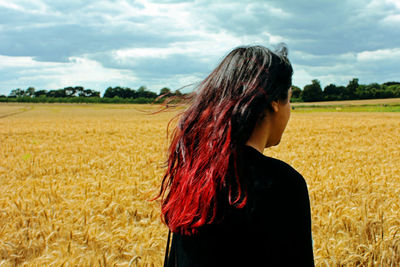 Woman standing on field against sky