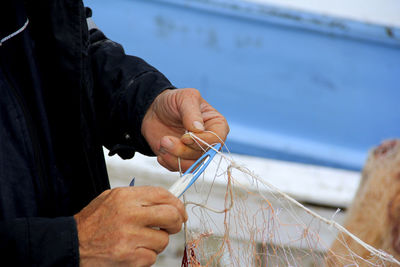 Fisherman repairing fishing net