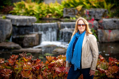 Portrait of woman wearing sunglasses while standing against autumn leaves