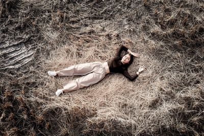 High angle view of woman lying down on field