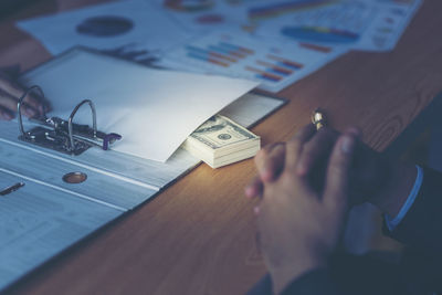 Close-up of businessman taking bribe on table at office