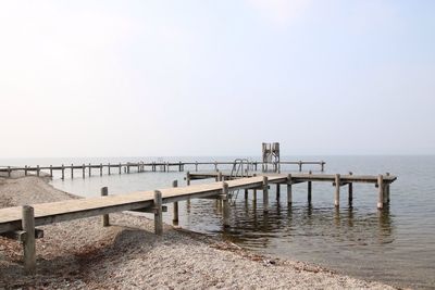 Pier on sea against clear sky